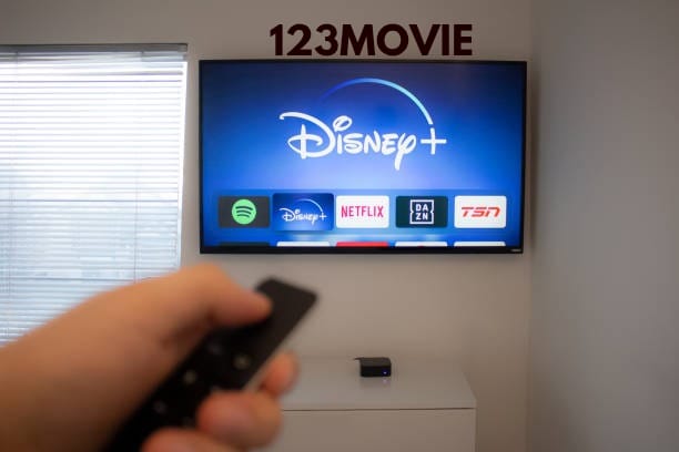A laptop screen displaying a 123movie platform with various movie titles.